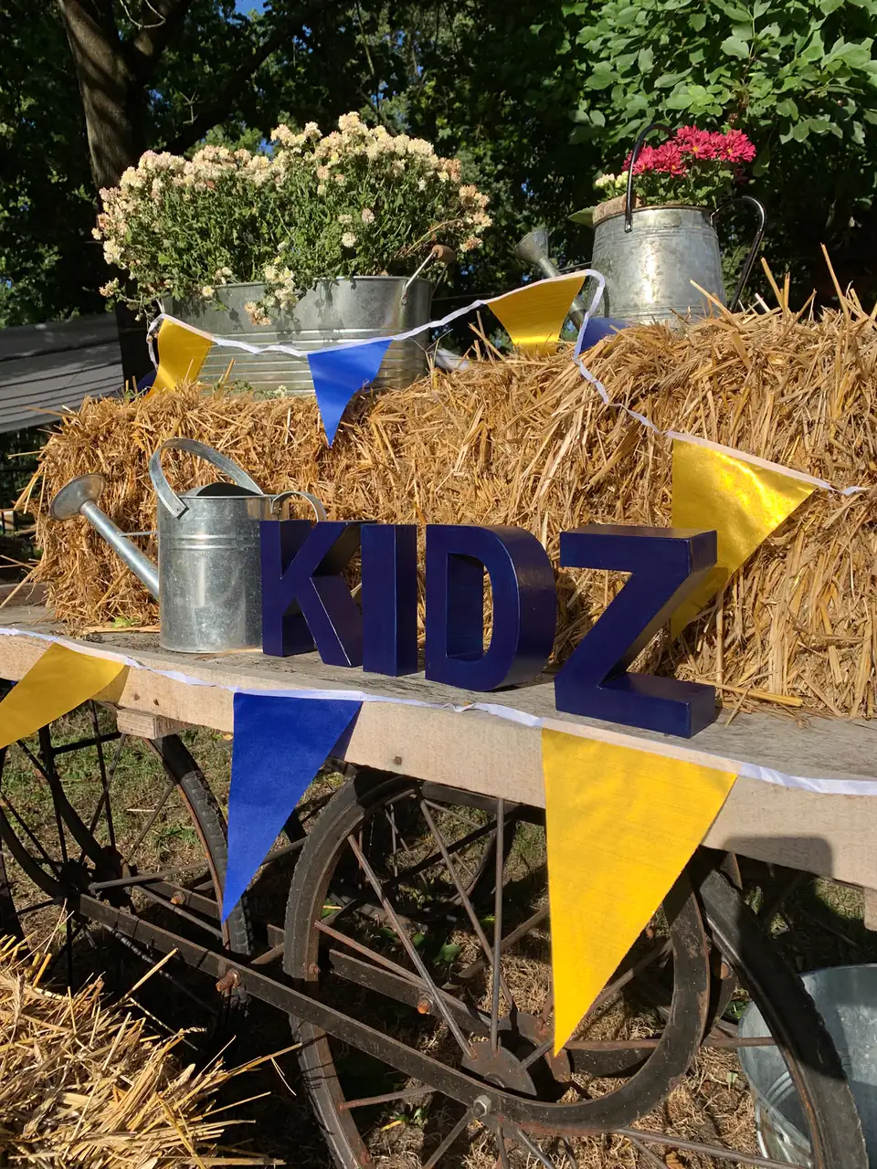 Dekorierter KIDZ-Wagen mit Heuballen, Blumen und Wimpeln