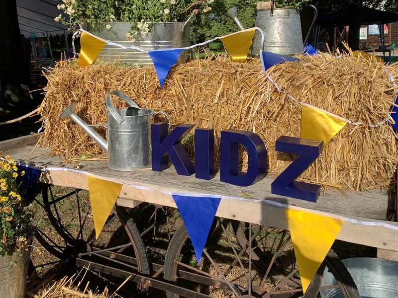 Dekorierter KIDZ-Wagen mit Heuballen, Blumen und Wimpeln
